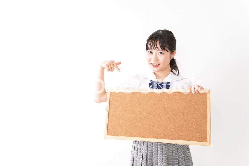 コルクボードを持つ学生