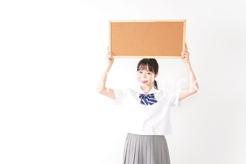 コルクボードを持つ学生