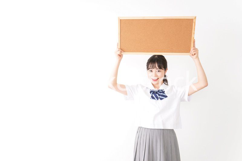 コルクボードを持つ学生