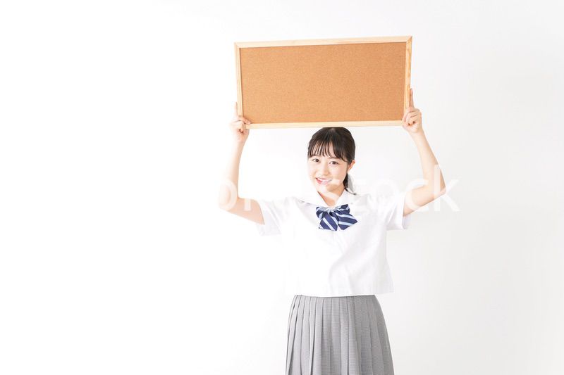 コルクボードを持つ学生