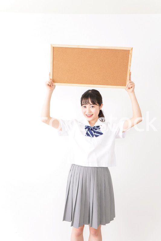 コルクボードを持つ学生