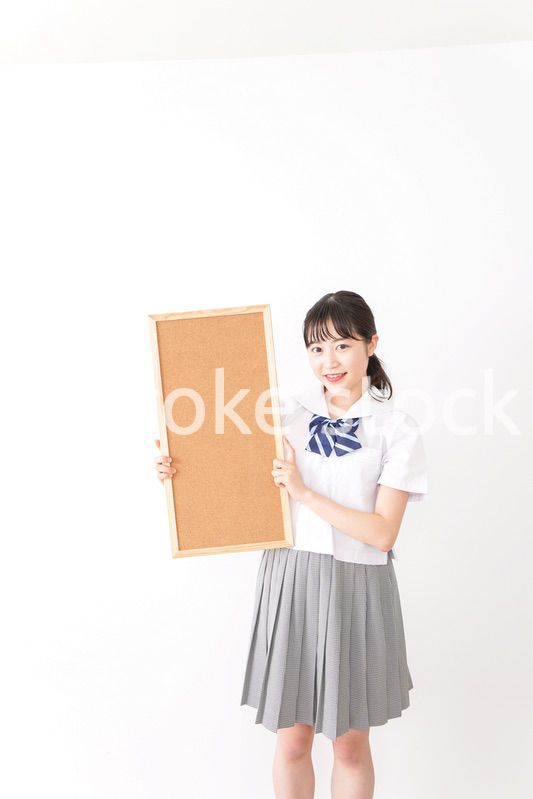 コルクボードを持つ学生