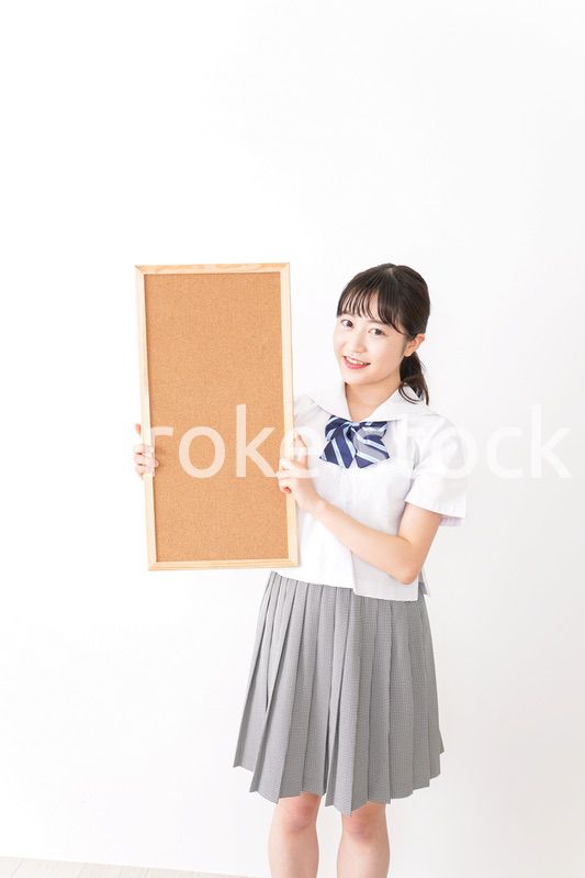 コルクボードを持つ学生