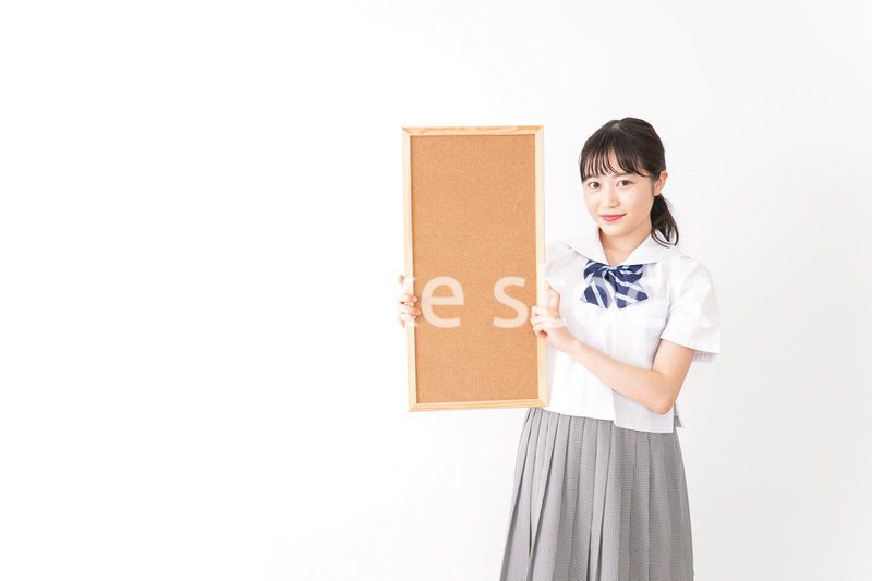 コルクボードを持つ学生