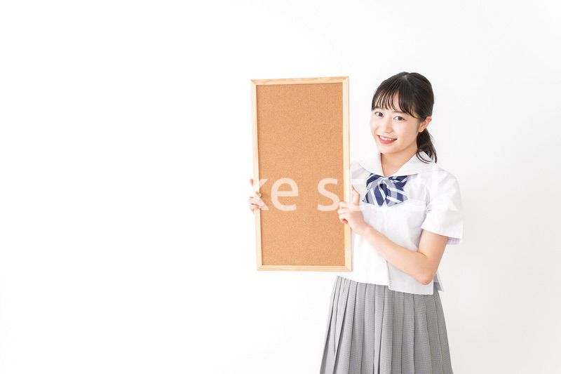 コルクボードを持つ学生
