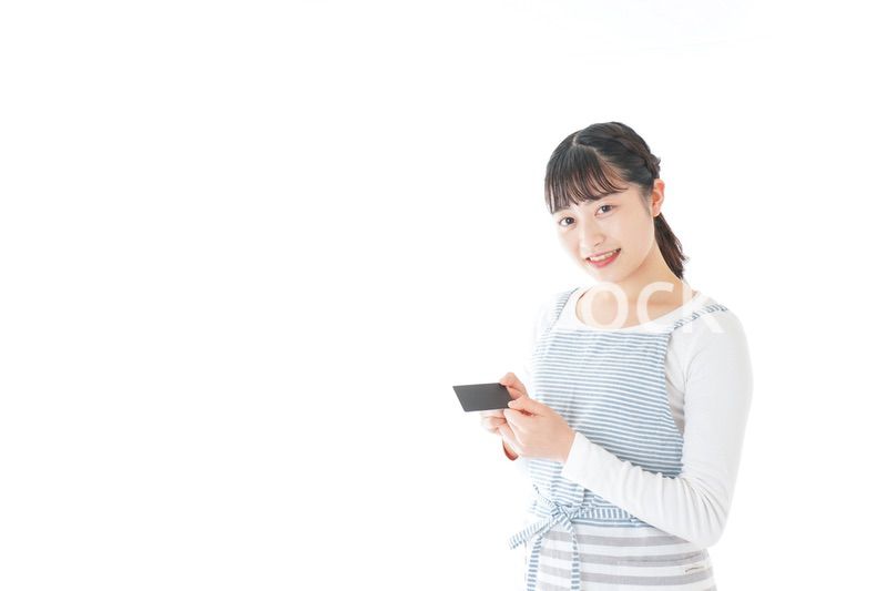 クレジットカード決済をする若いカフェスタッフ