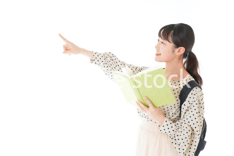 上を指差す制服を着た女子学生