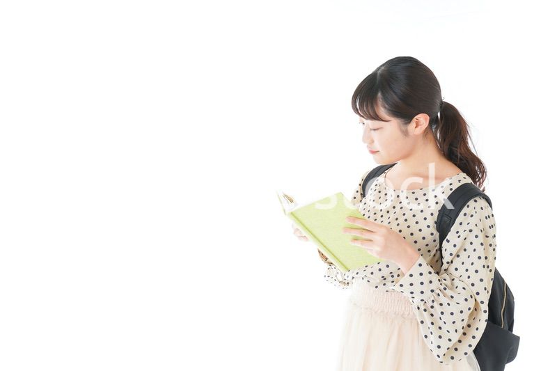 上を指差す制服を着た女子学生