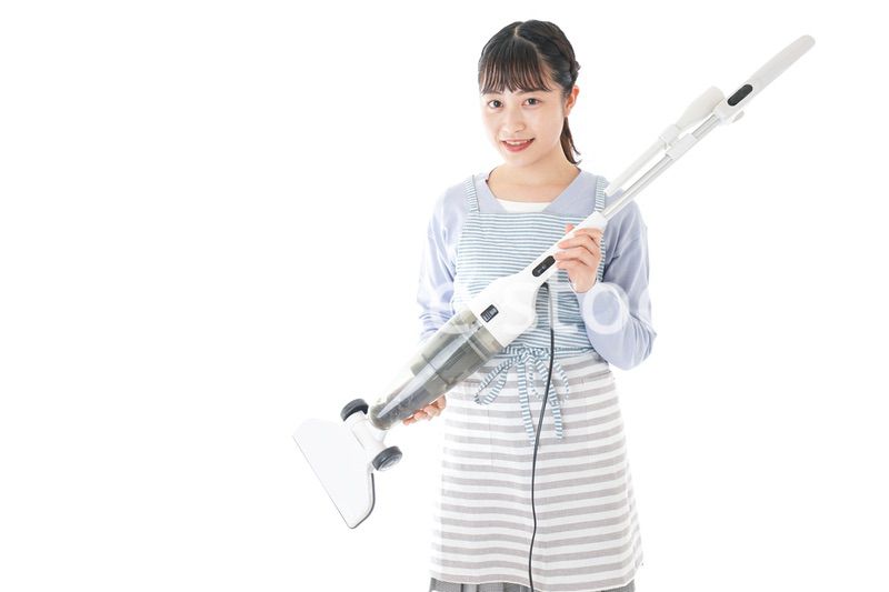 掃除機を使う若い女性
