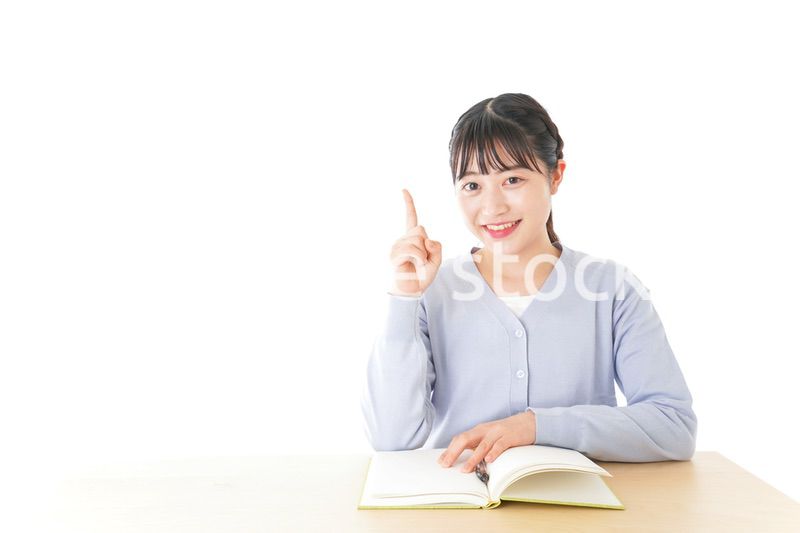 勉強をしながら指を指す若い女子学生