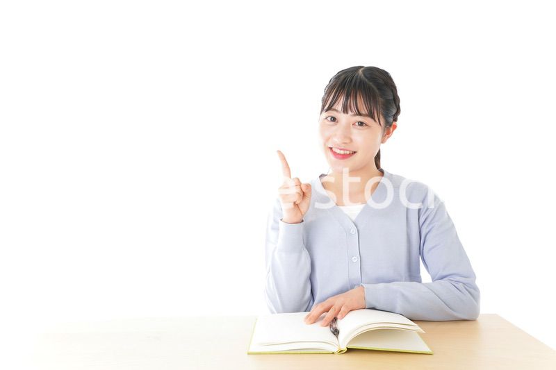 勉強をしながら指を指す若い女子学生