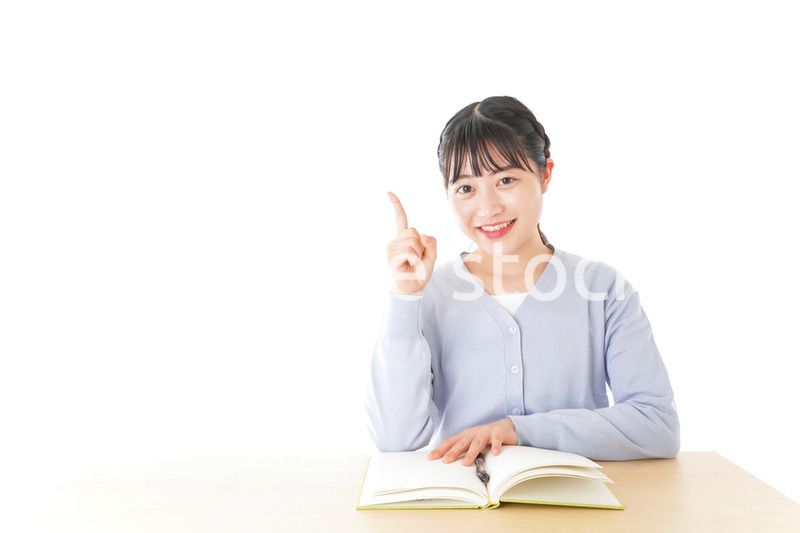 勉強をしながら指を指す若い女子学生
