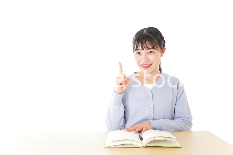勉強をしながら指を指す若い女子学生