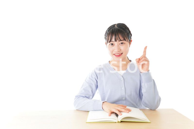 勉強をしながら指を指す若い女子学生