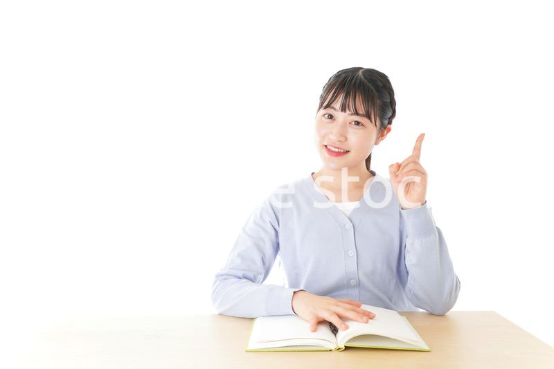 勉強をしながら指を指す若い女子学生