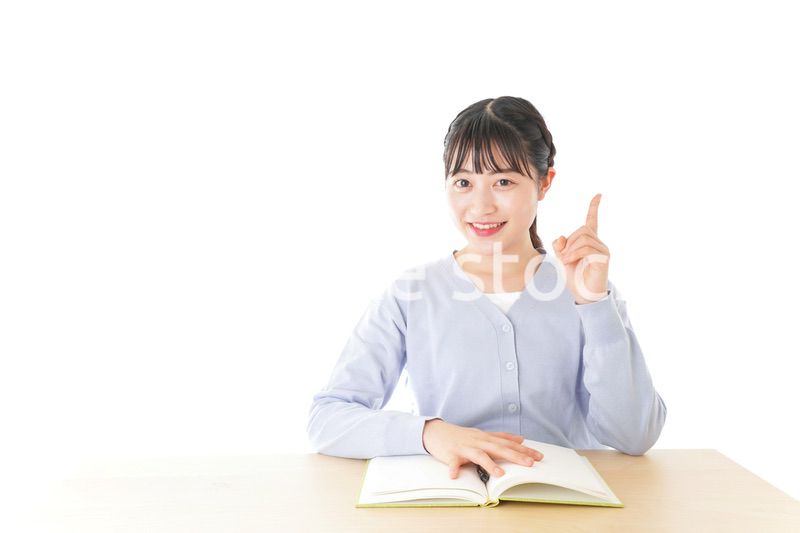 勉強をしながら指を指す若い女子学生