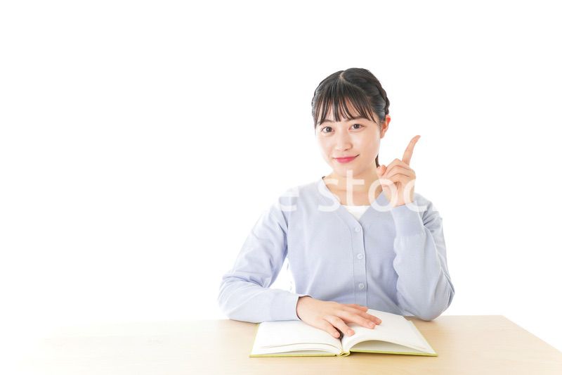 勉強をしながら指を指す若い女子学生