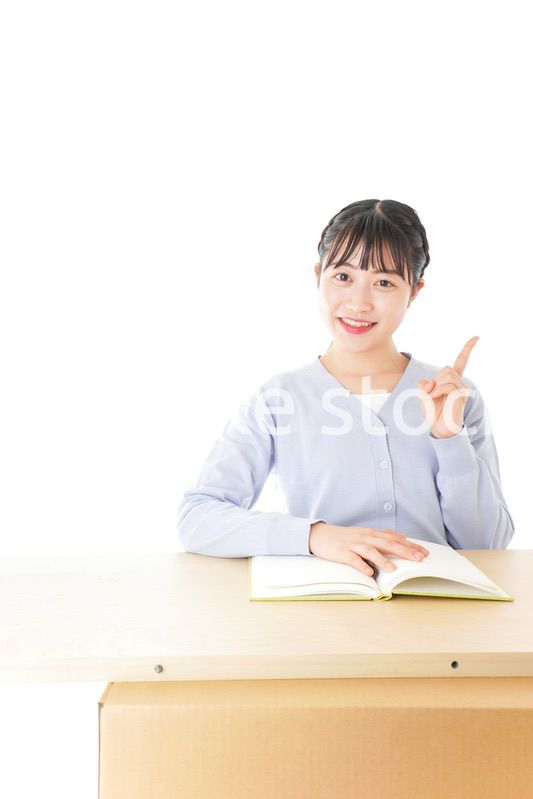 勉強をしながら指を指す若い女子学生