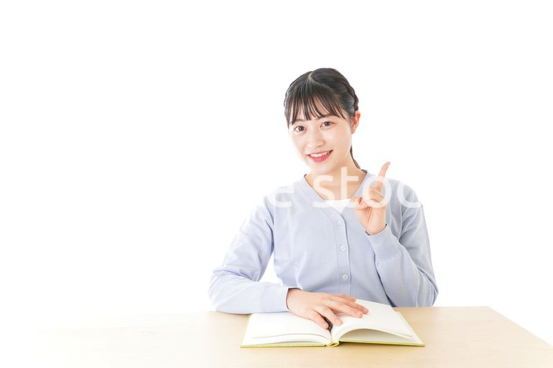 勉強をしながら指を指す若い女子学生