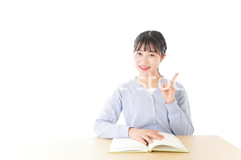 勉強をしながら指を指す若い女子学生