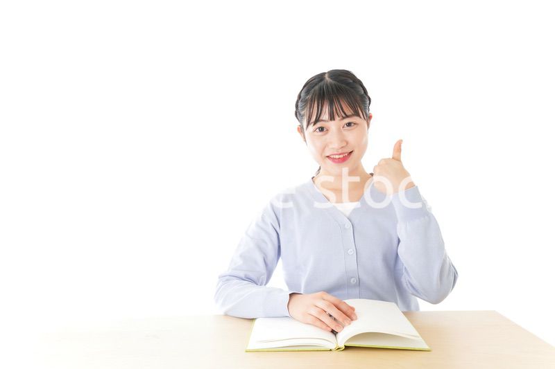 勉強をしながら指を指す若い女子学生