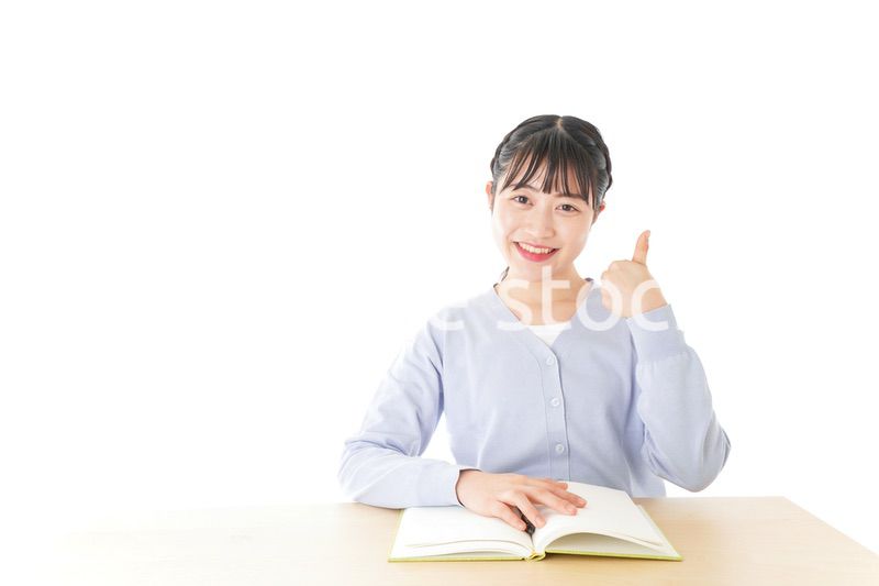 勉強をしながら指を指す若い女子学生