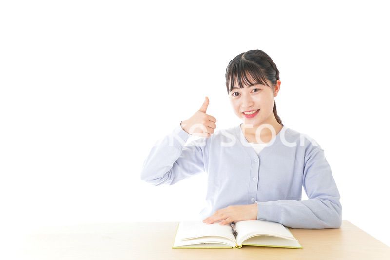 勉強をしながら指を指す若い女子学生