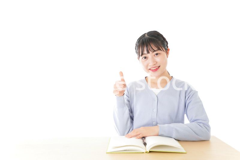 勉強をしながら指を指す若い女子学生