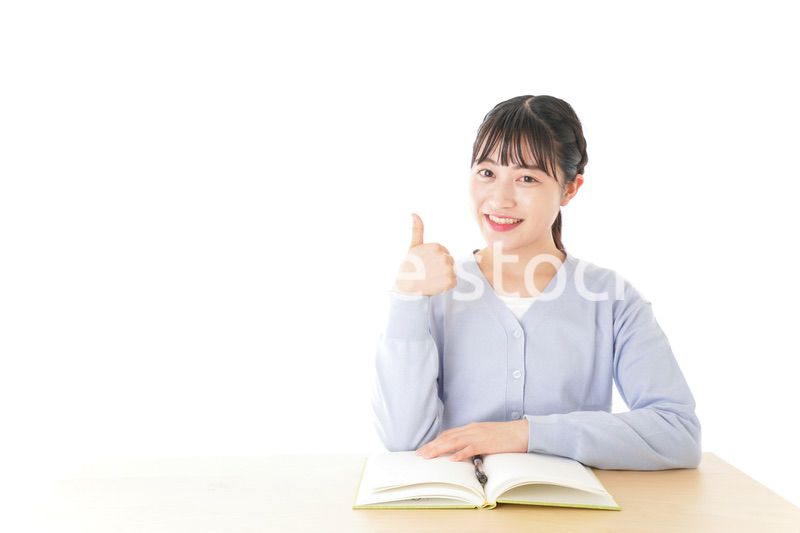 勉強をしながら指を指す若い女子学生