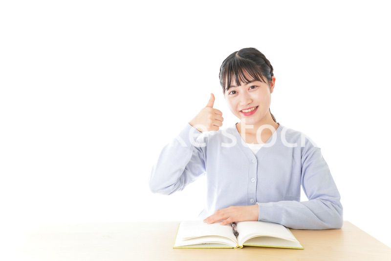 勉強をしながら指を指す若い女子学生