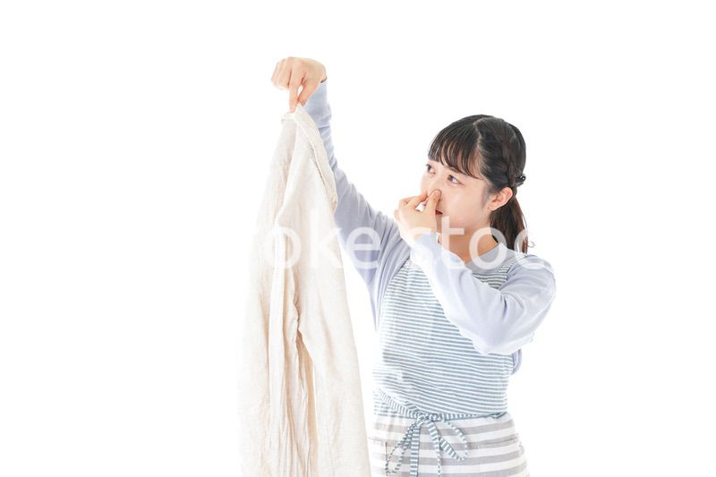 洗濯物を臭う若い女性