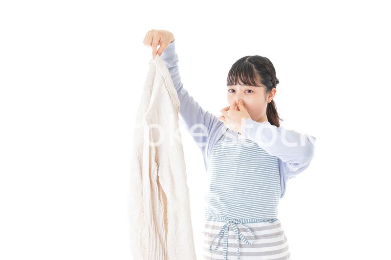 洗濯物を臭う若い女性