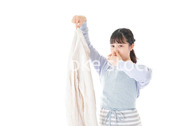 洗濯物を臭う若い女性