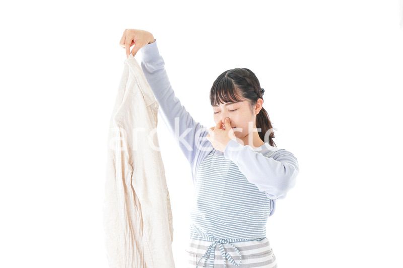 洗濯物を臭う若い女性