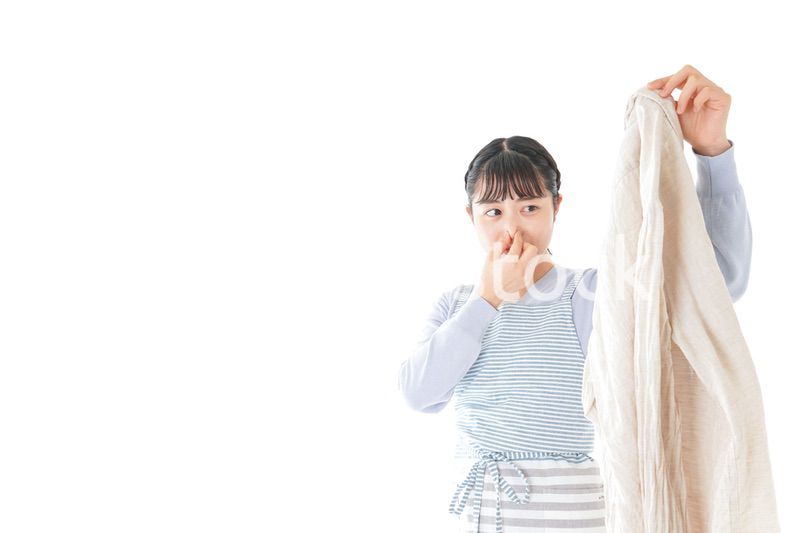 洗濯物を臭う若い女性