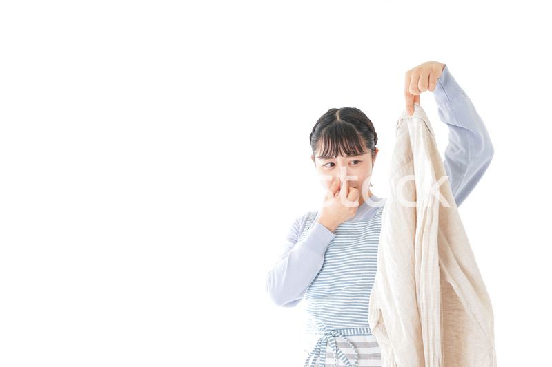 洗濯物を臭う若い女性