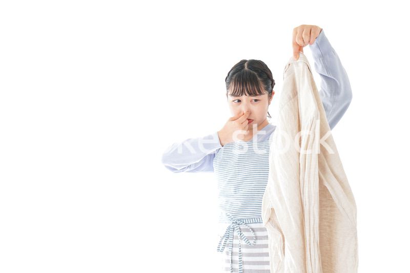 洗濯物を臭う若い女性