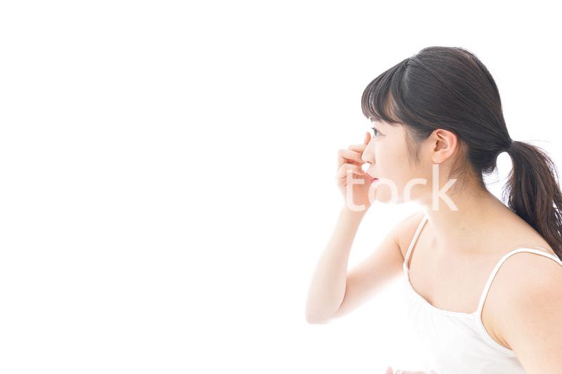 コンタクトレンズを装着する若い女性