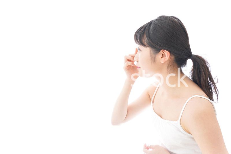 コンタクトレンズを装着する若い女性