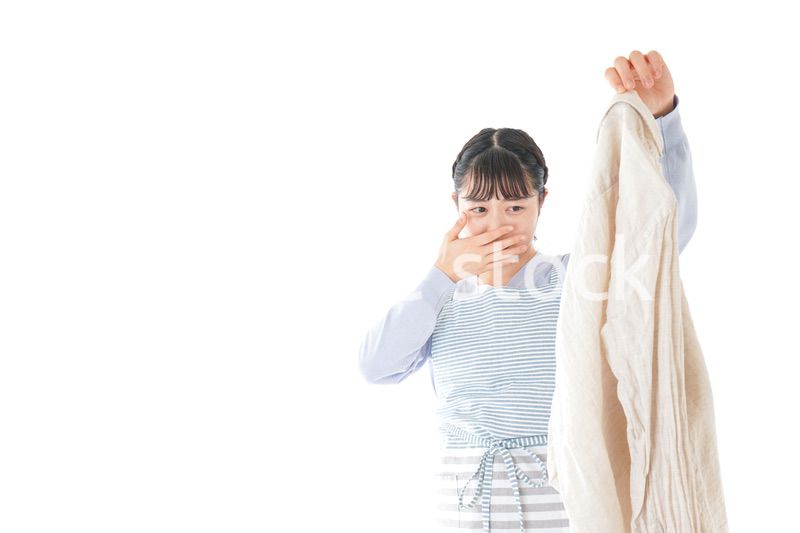 洗濯物を臭う若い女性