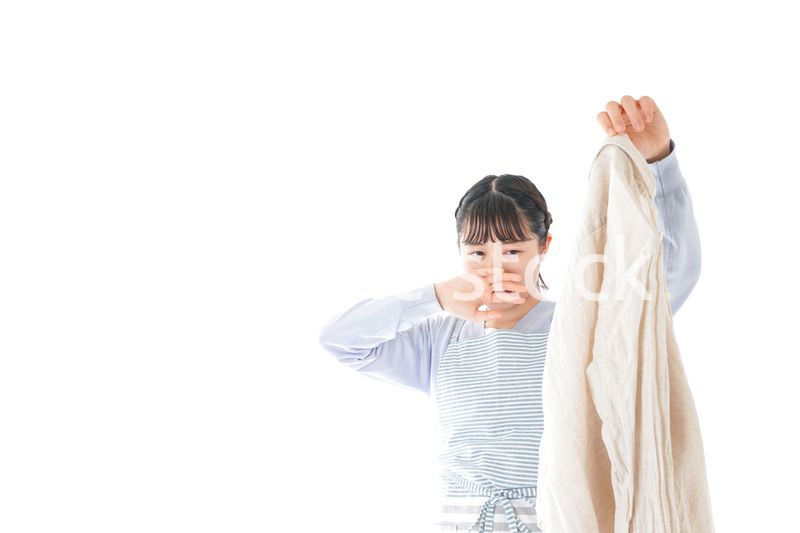 洗濯物を臭う若い女性
