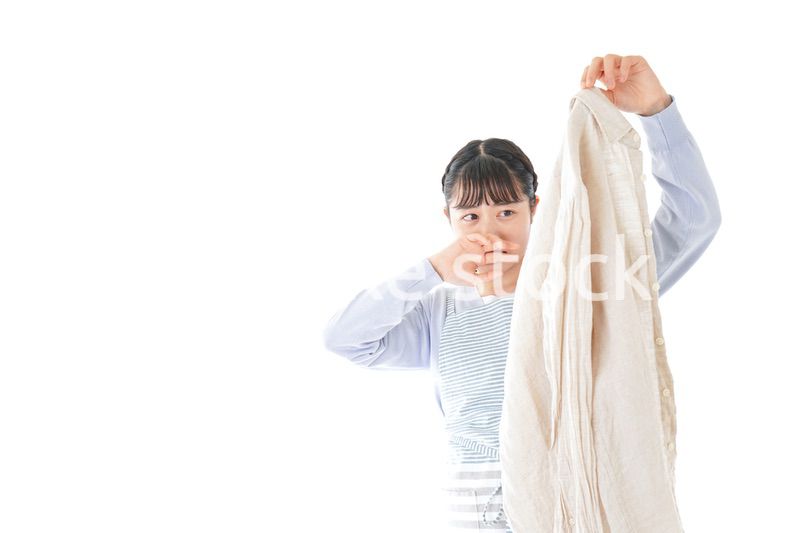 洗濯物を臭う若い女性