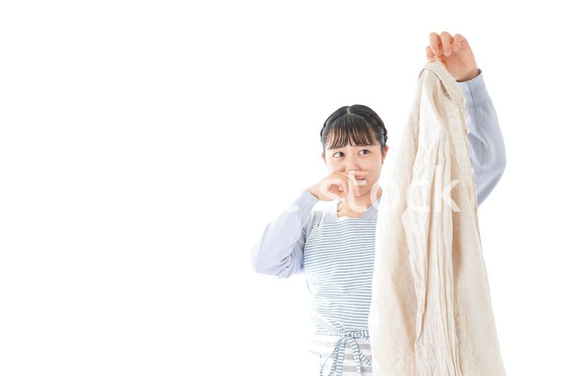 洗濯物を臭う若い女性