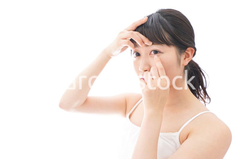 コンタクトレンズを装着する若い女性