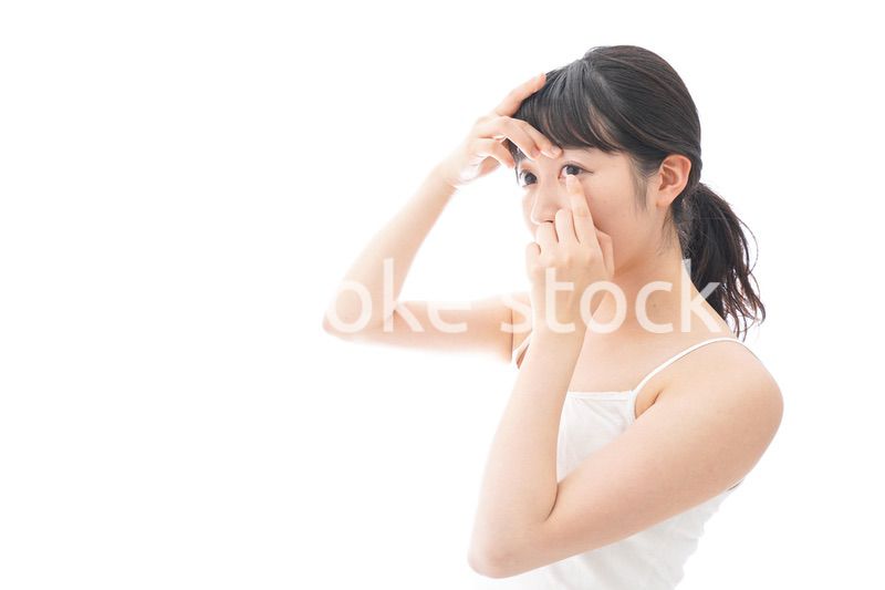 コンタクトレンズを装着する若い女性