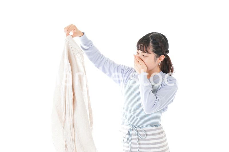 洗濯物を臭う若い女性