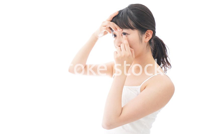 コンタクトレンズを装着する若い女性