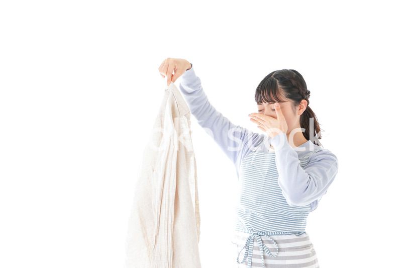 洗濯物を臭う若い女性
