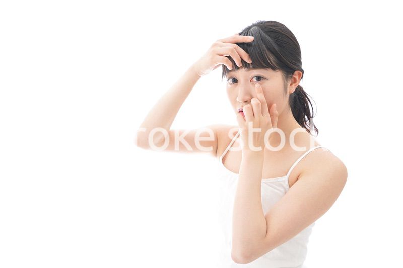 コンタクトレンズを装着する若い女性