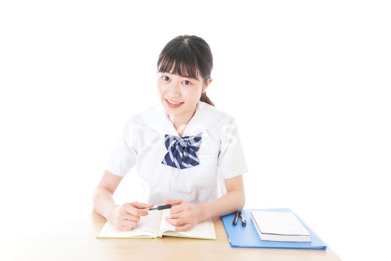 机で勉強をする制服姿の女子学生